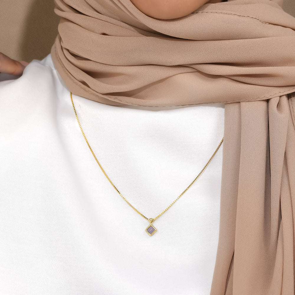 Essential petite square pendant worn with a white top and beige scarf
