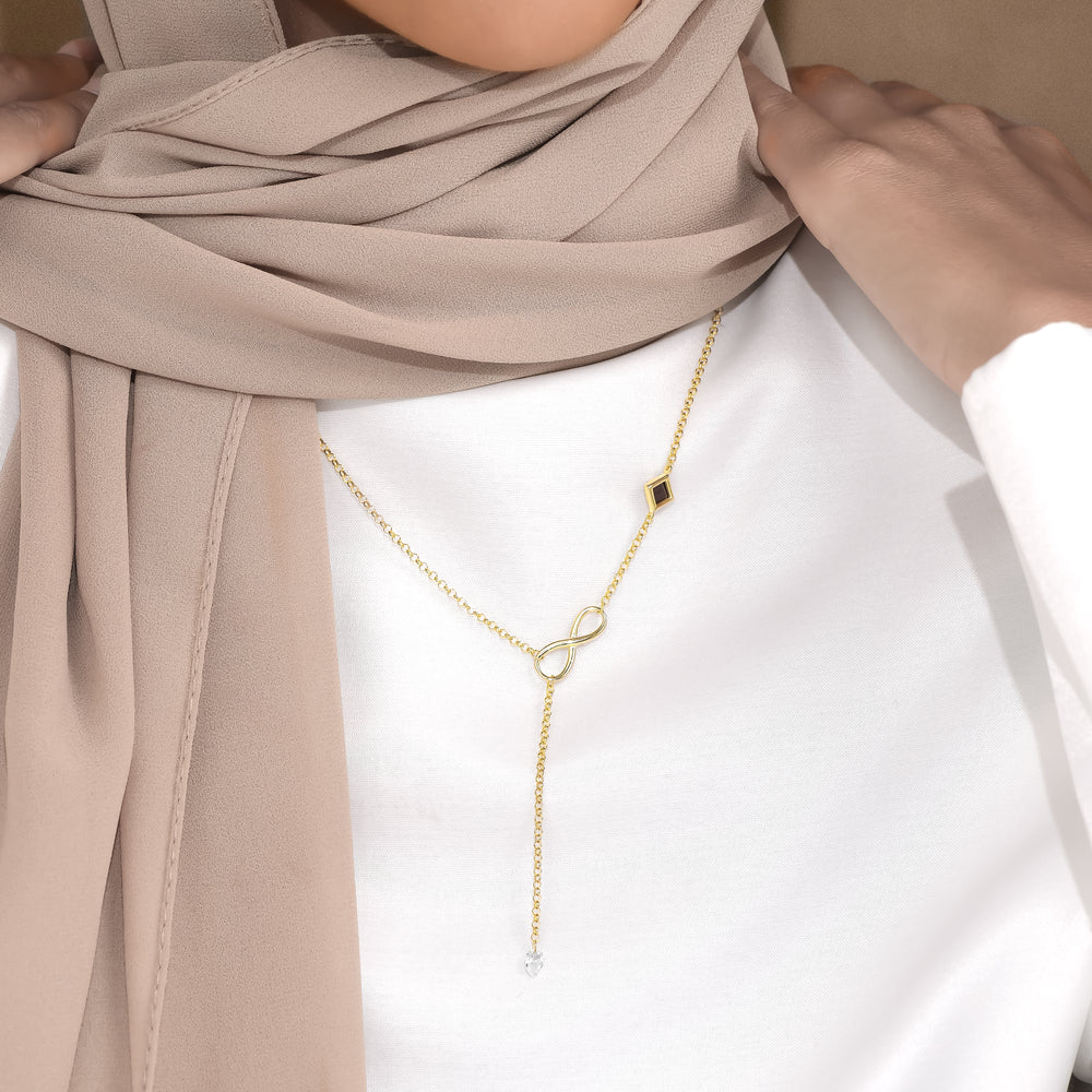 Bond infinity drop necklace worn with a white top and beige scarf