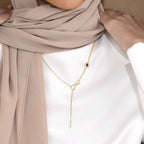 Bond infinity drop necklace worn with a white top and beige scarf