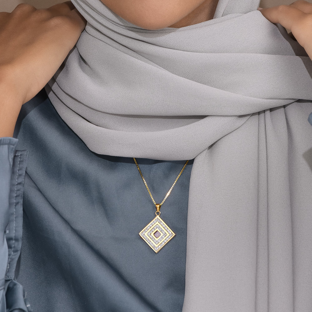 Legacy layered square pendant worn with a blue satin top and grey scarf